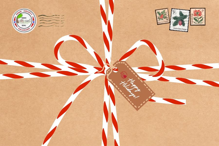 Old style present wrapped with red and white striped bow and tag reading, "Happy Holidays!."